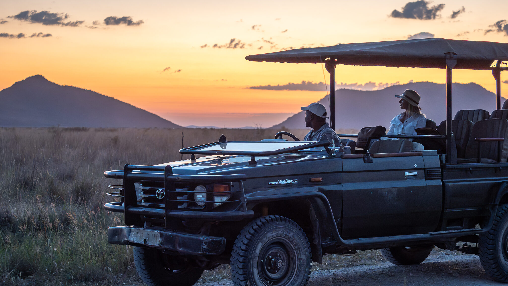 A woman and a safari guide in a vehicle